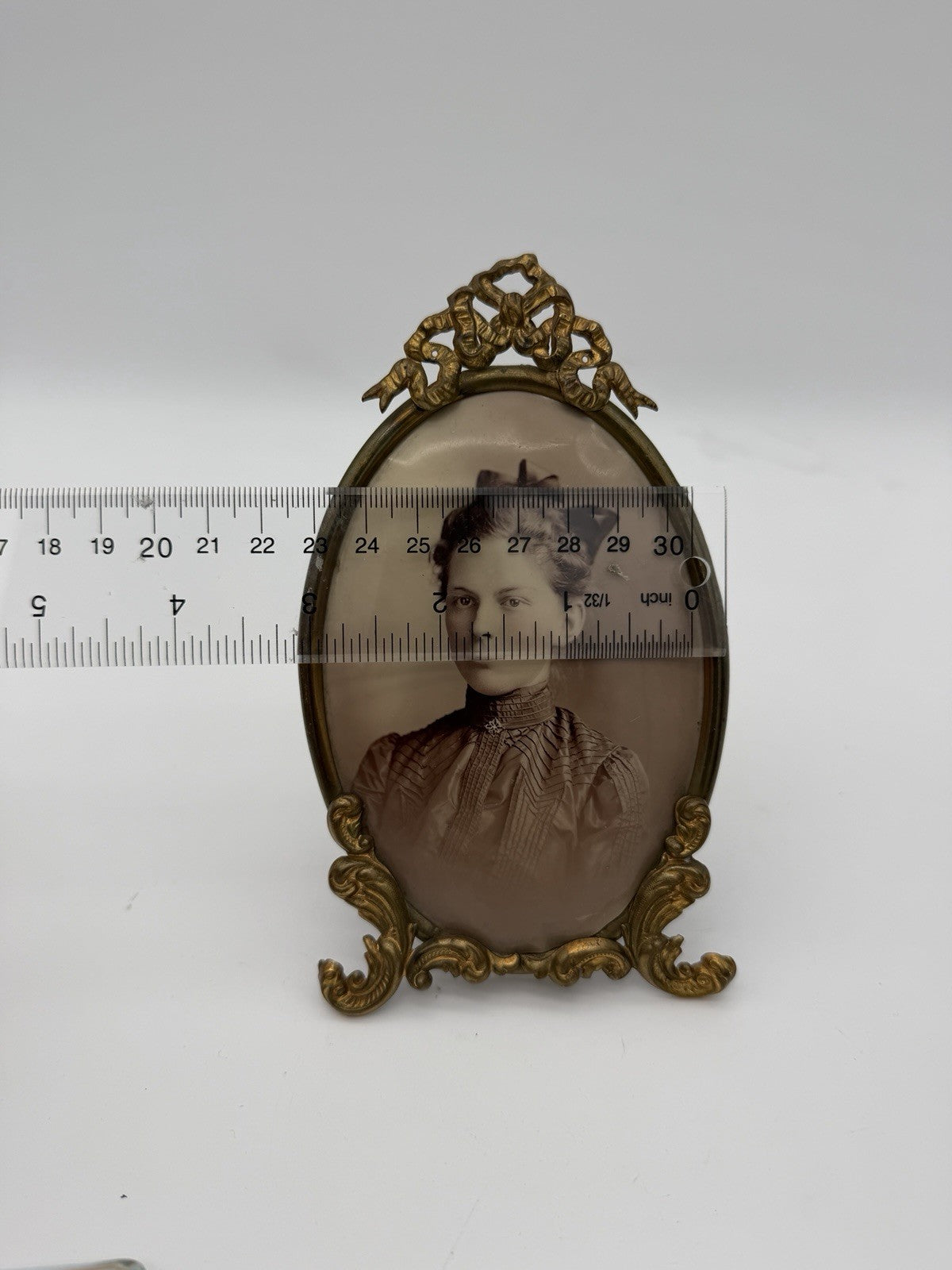 Antique oval picture frame ornate brass scrolling top ribbon accent