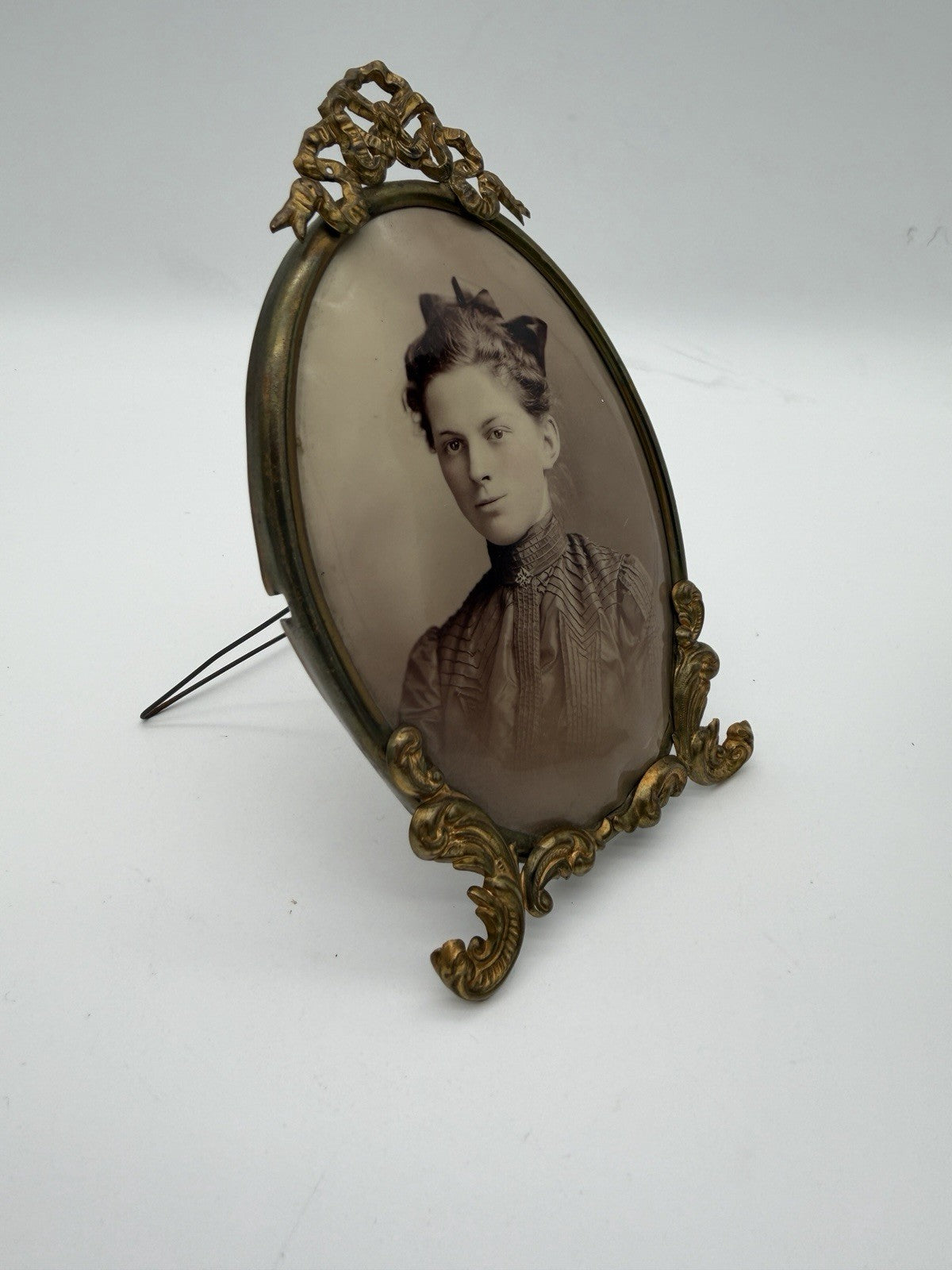 Antique oval picture frame ornate brass scrolling top ribbon accent