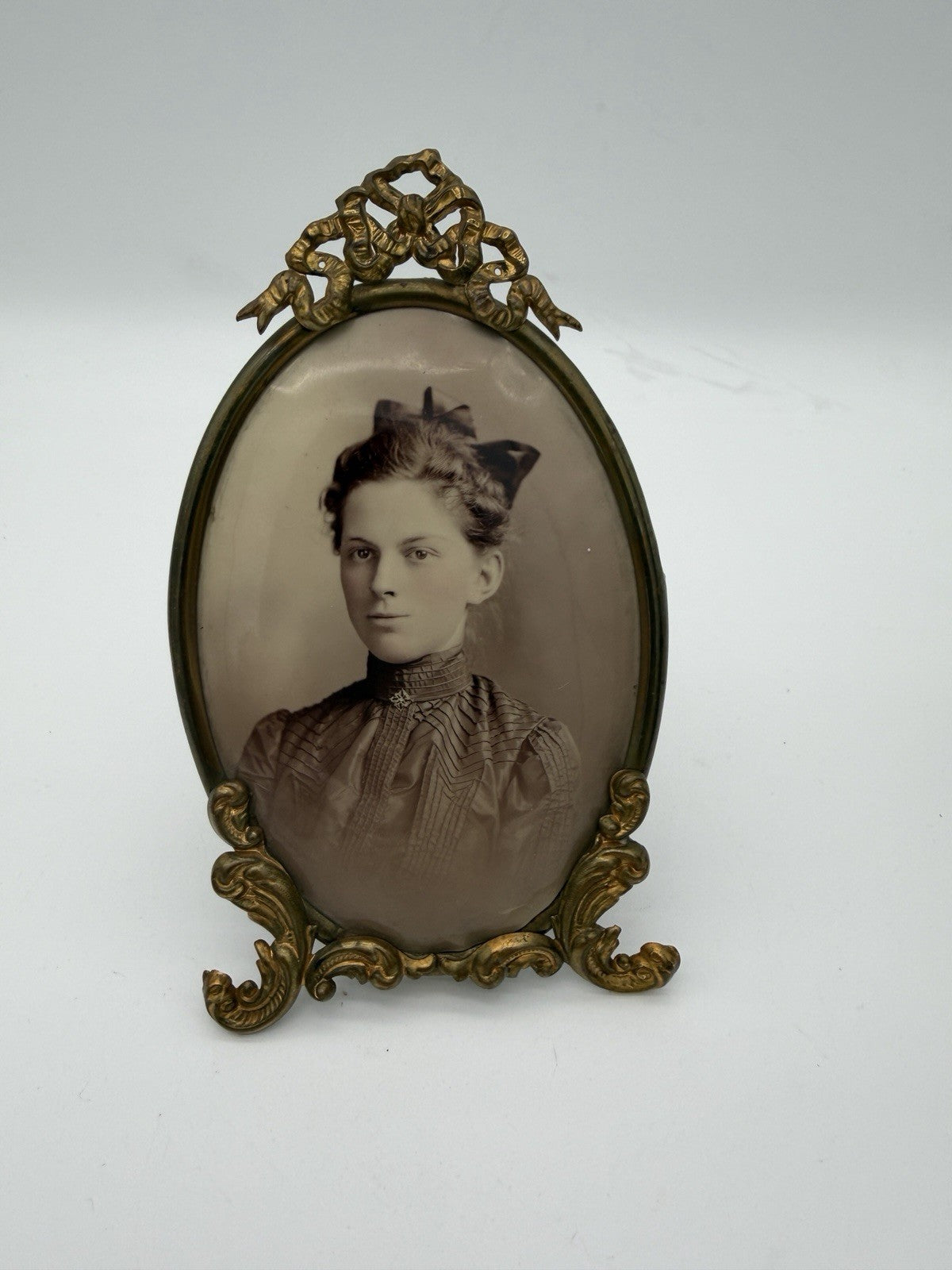 Antique oval picture frame ornate brass scrolling top ribbon accent