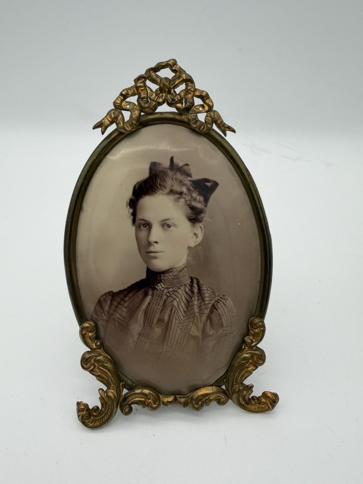 Antique oval picture frame ornate brass scrolling top ribbon accent