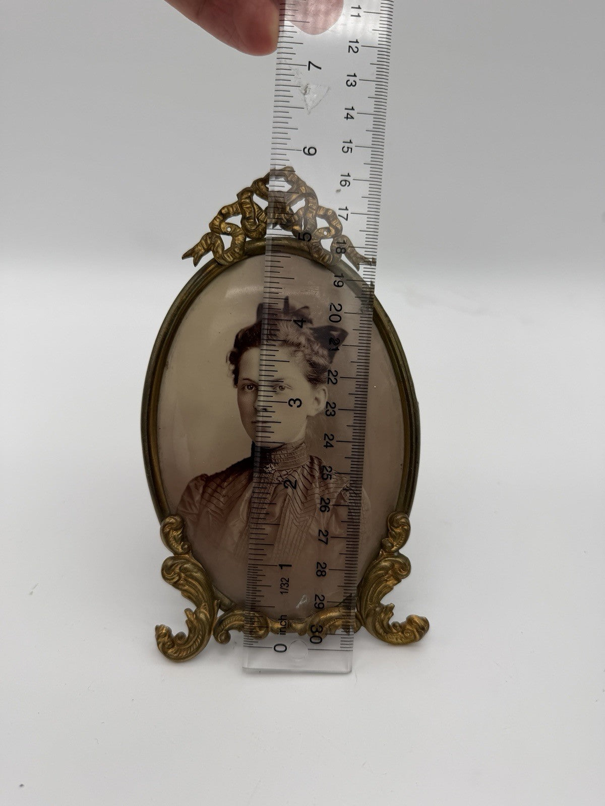 Antique oval picture frame ornate brass scrolling top ribbon accent