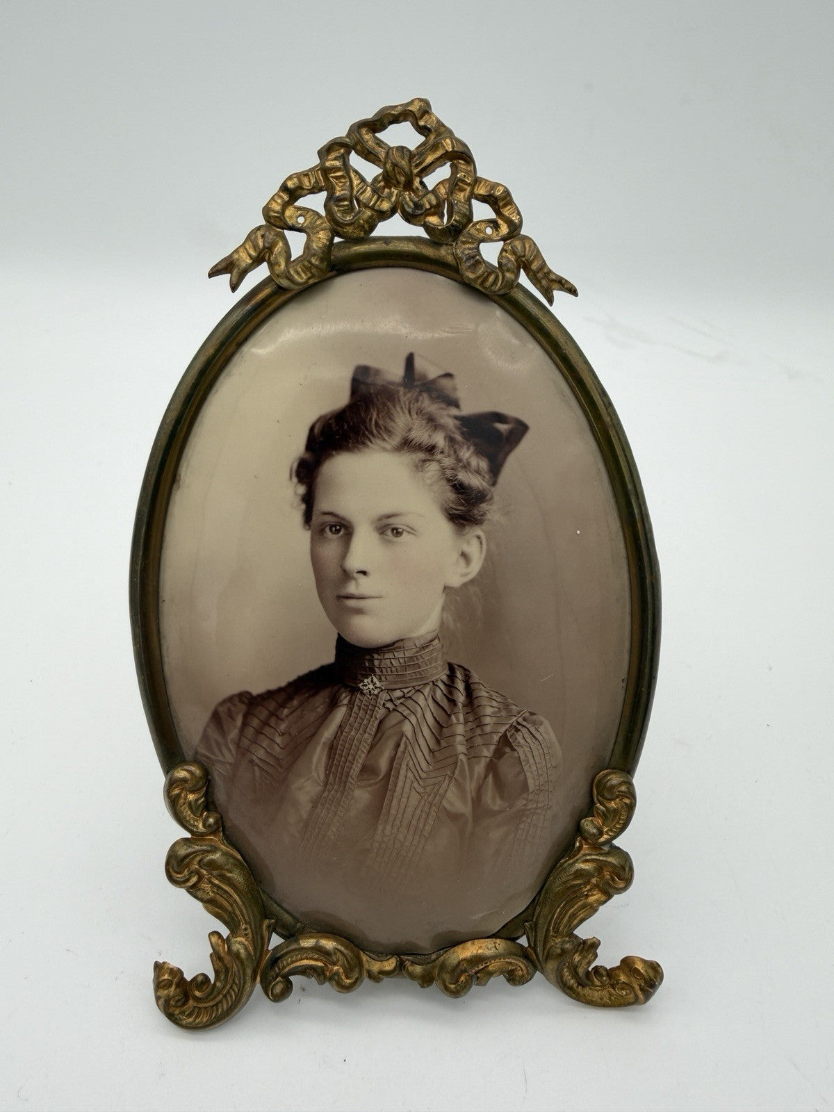 Antique oval picture frame ornate brass scrolling top ribbon accent