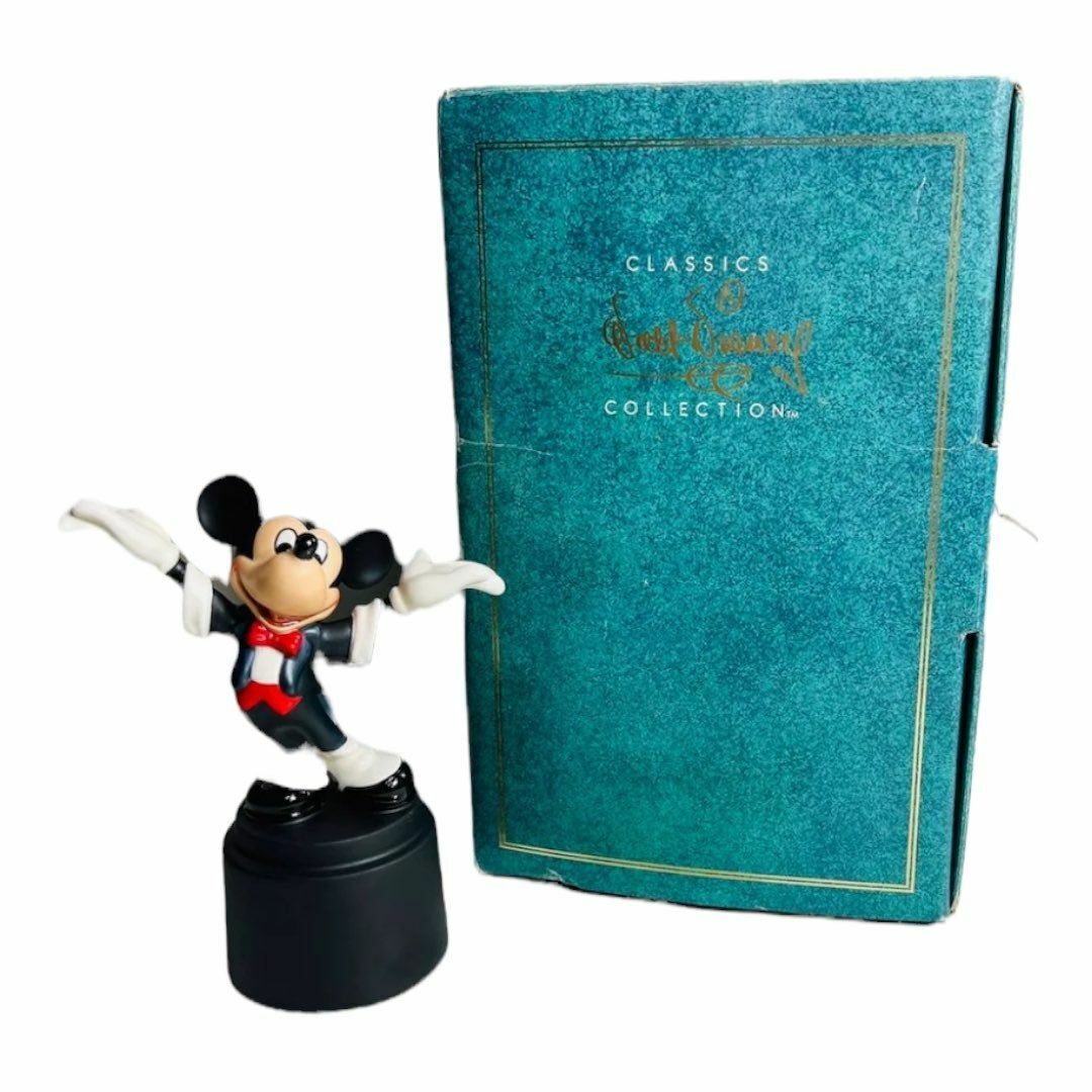 a mickey mouse figurine next to a book