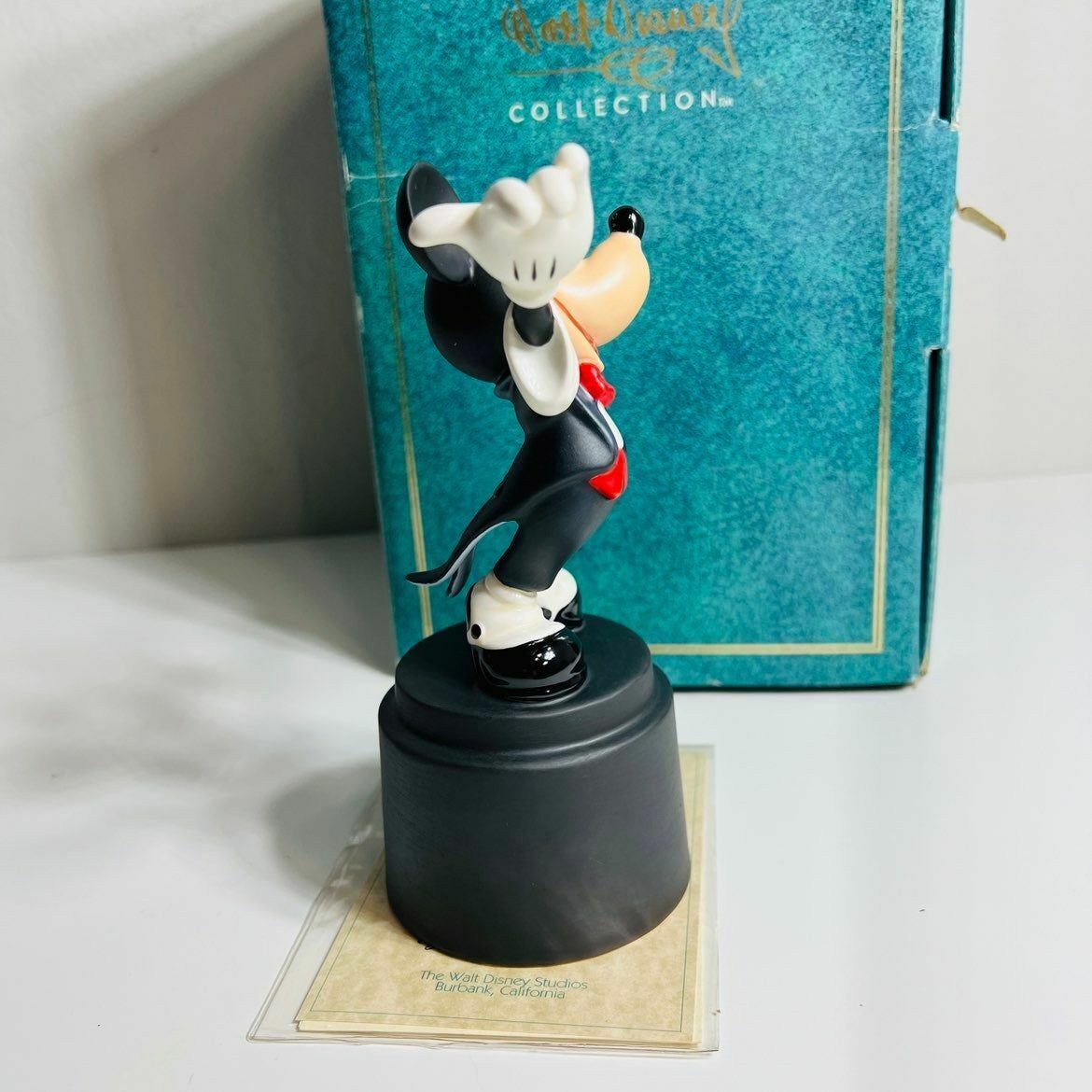 a figurine of a mickey mouse in front of a blue box