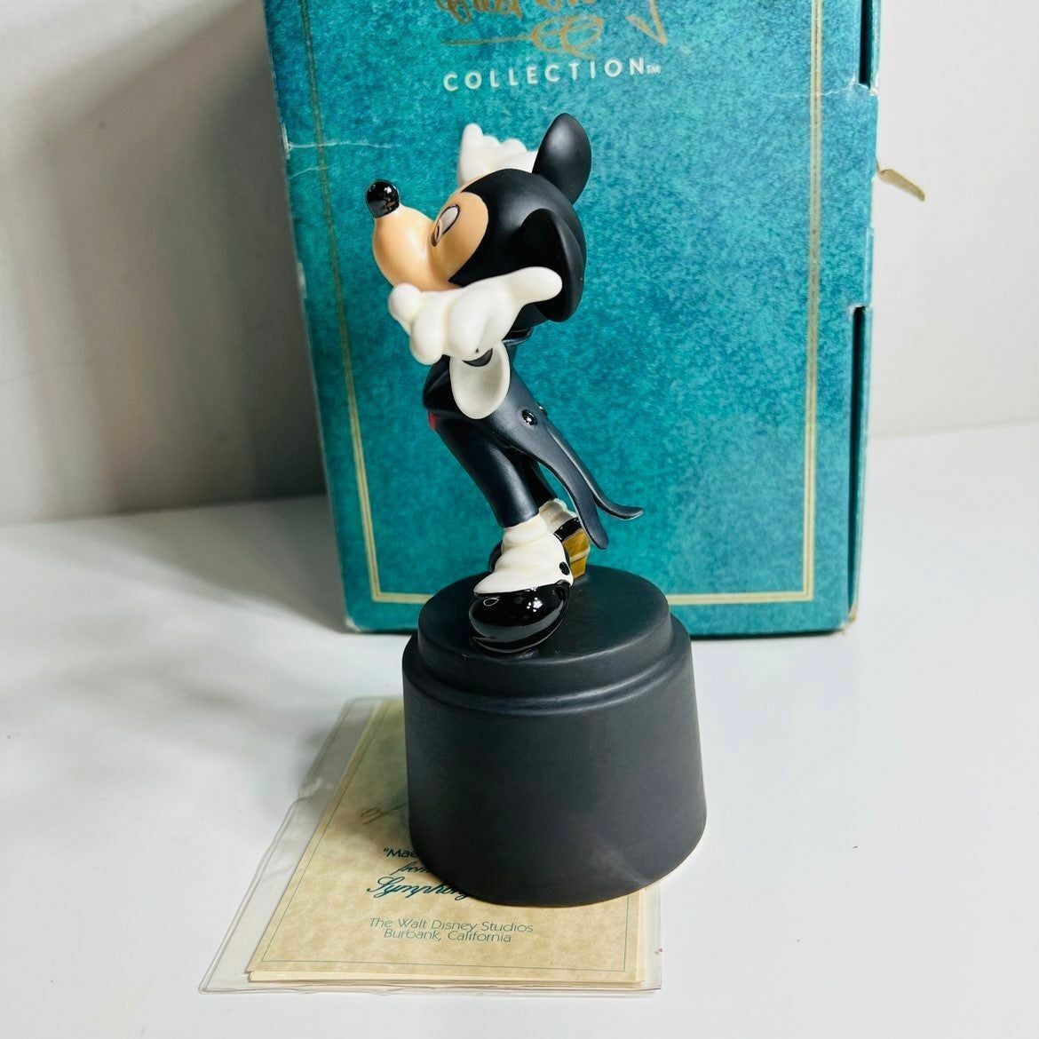 a figurine of a mickey mouse in front of a box