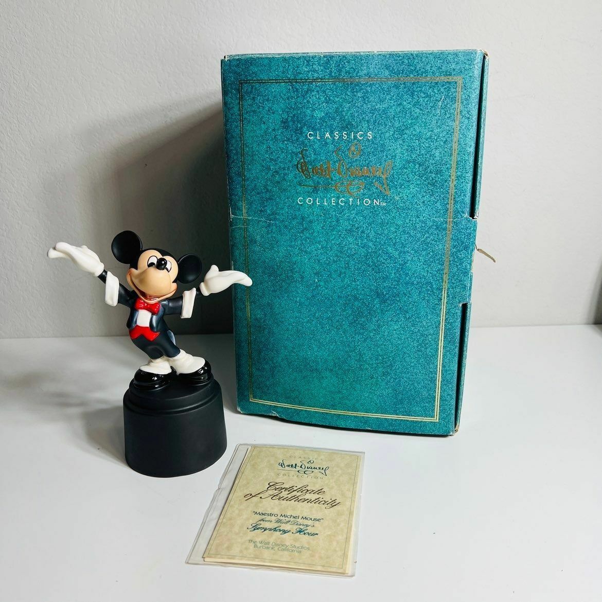 a mickey mouse figurine next to a book