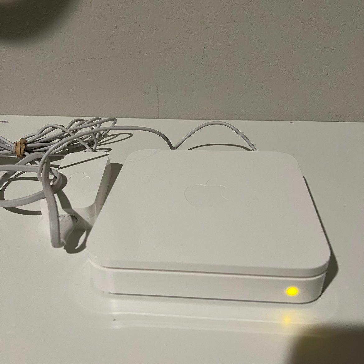 a white apple router sitting on top of a table