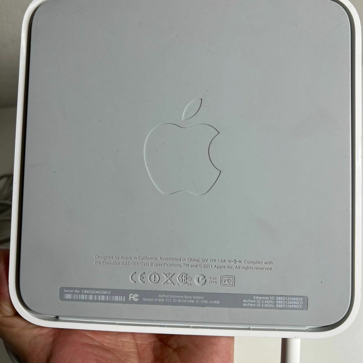 a hand is holding a white apple computer